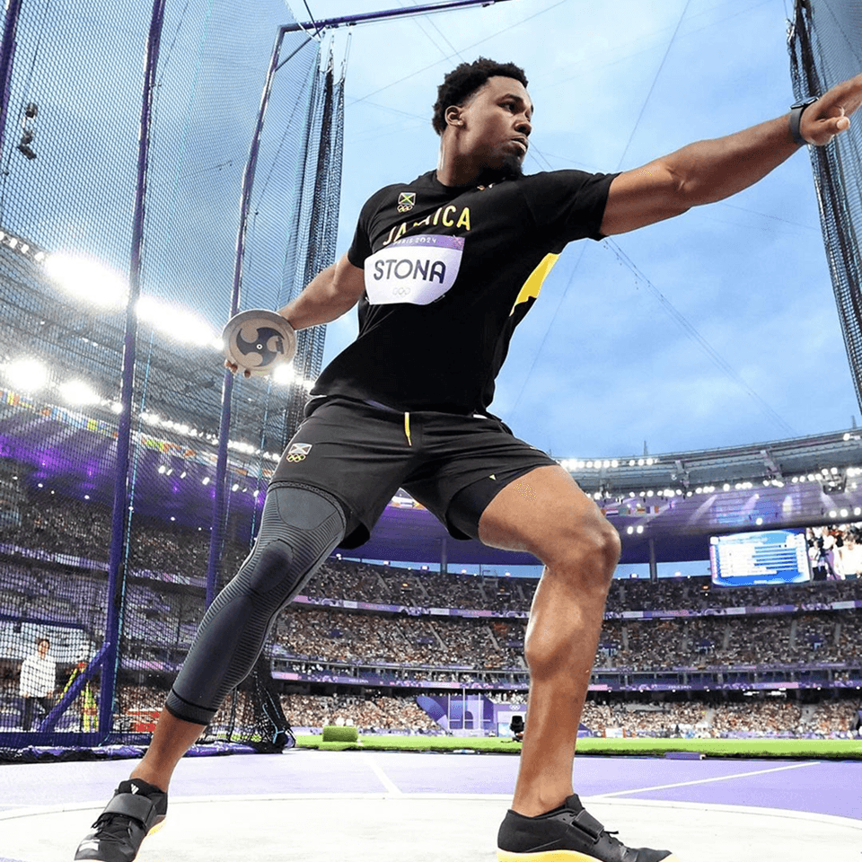 Jamaican discus athlete competing in a stadium.